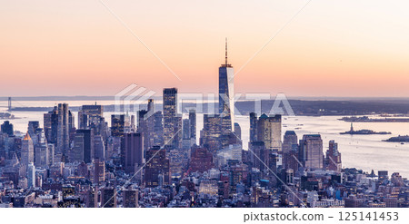 Stunning sunset view over Manhattan Downtown with glowing skyscrapers and warm city lights 125141453