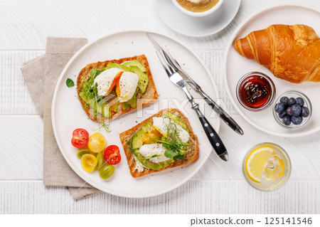 Breakfast with delicious avocado toasts and crispy croissant 125141546
