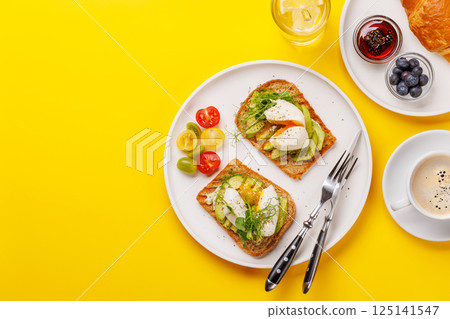 Breakfast with delicious avocado toasts and crispy croissant Breakfast with delicious avocado toasts and crispy croissant 125141547