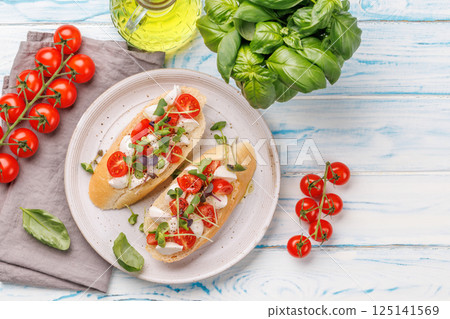 Delicious antipasto caprese toast topped with fresh mozzarella 125141569