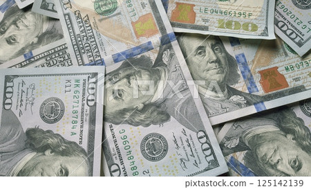 A substantial pile of US Dollar bills placed neatly on a table for observation or use A substantial pile of US Dollar bills placed neatly on a table for observation or use 125142139