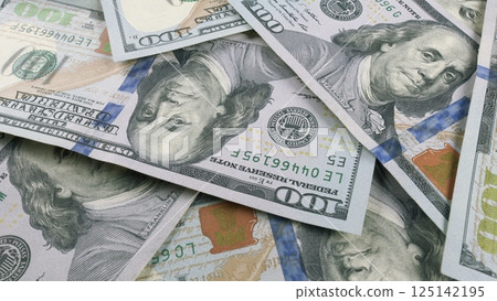 A collection of scattered US Dollar Bills laid out on a surface for viewing and counting 125142195
