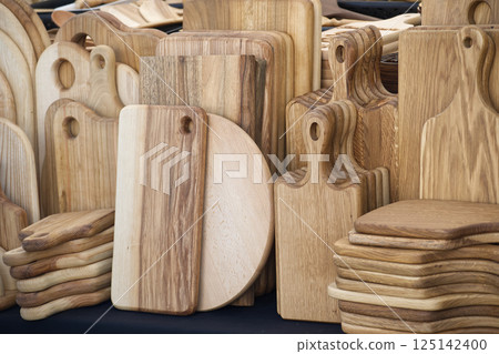 Handcrafted wooden cutting boards in various shapes and sizes are displayed at local artisan market Handcrafted wooden cutting boards in various shapes and sizes are displayed at local artisan market 125142400
