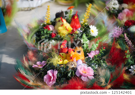 Easter decorations with colorful chicks, feathers, flowers, speckled eggs create festive atmosphere. 125142401