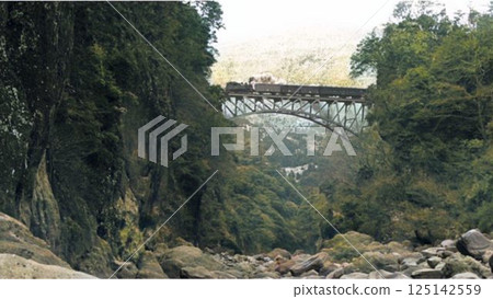 A mixed train crossing an arch bridge on the Takamori Line in the past, brought back to life in color 125142559