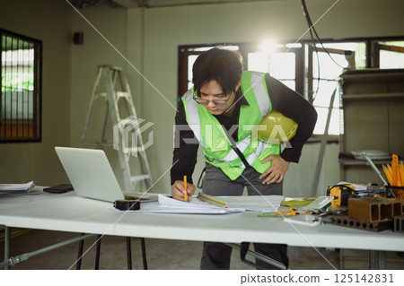 Engineer reviewing construction blueprints at renovation site 125142831