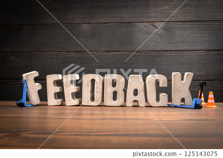 FEEDBACK Text with Traffic Cones and Forklift Toy on Desk FEEDBACK Text with Traffic Cones and Forklift Toy on Desk 125143075