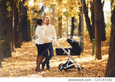 Beautiful parents is in the forest with pram having a walk Beautiful parents is in the forest with pram having a walk 125143162