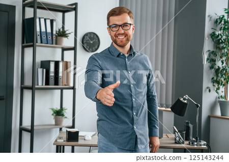 Giving hand. Man is working in the modern office. Conception of business and freelance Giving hand. Man is working in the modern office. Conception of business and freelance 125143244