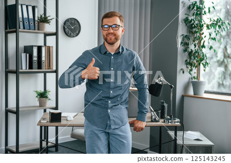 Showing thumb up. Man is working in the modern office. Conception of business and freelance Showing thumb up. Man is working in the modern office. Conception of business and freelance 125143245