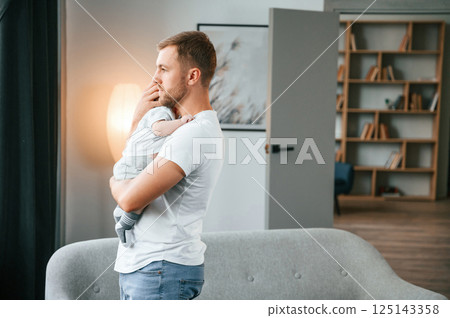 Holding baby in hands. Father with toddler is at home, taking care of his son 125143358