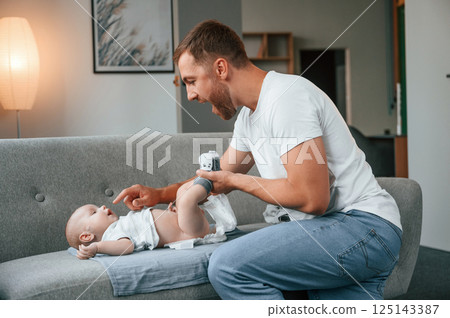 Father with toddler is at home, taking care of his son. Changing diapers 125143387