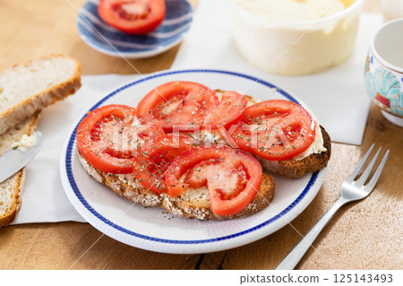 Two bruschettas with tomato slices on a plate 125143493
