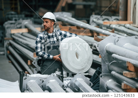 Factory male worker in uniform is indoors 125143633