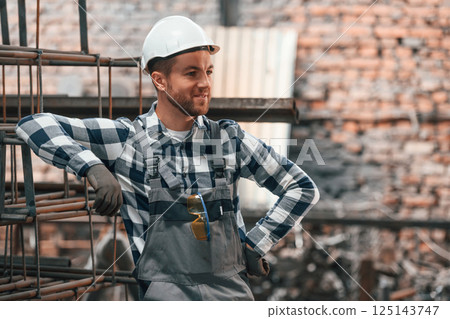 Friendly factory male worker in uniform is indoors Friendly factory male worker in uniform is indoors 125143747