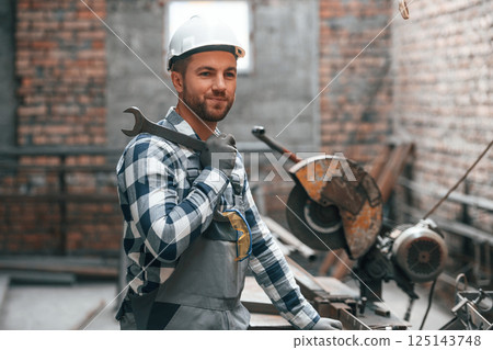 Friendly factory male worker in uniform is indoors Friendly factory male worker in uniform is indoors 125143748