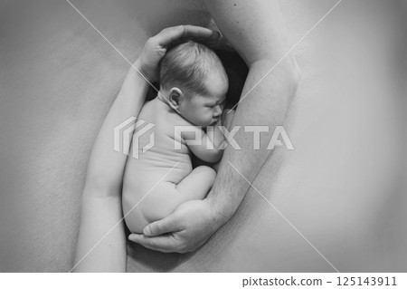 A newborn baby is wrapped in diapers with a wool cap in a basket. Swaddling, maternity hospital, family, ivf, life planning, parenting. A mother's love for her child. Baby food. High quality photo 125143911