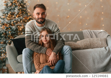 Woman is sitting. Lovely young couple are celebrating New Year at home 125144081