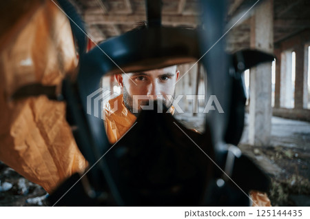 View through the respirator. Man dressed in chemical protection suit in the ruins of the post apocalyptic building 125144435