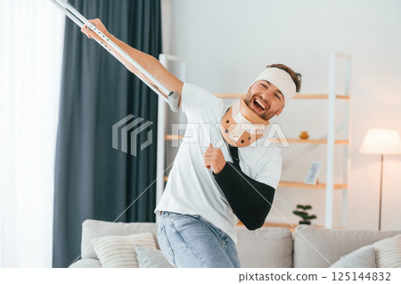 Man with crutches is at home indoors. Having injuries 125144832