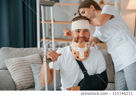 Taking care of bandage on the head. Woman is helping injured man at home 125146231