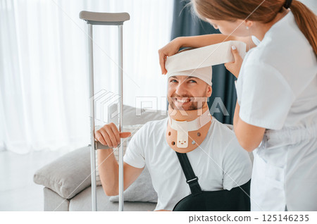 Woman is helping injured man at home Woman is helping injured man at home 125146235