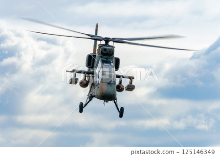 A military helicopter flying against a blue sky A military helicopter flying against a blue sky 125146349