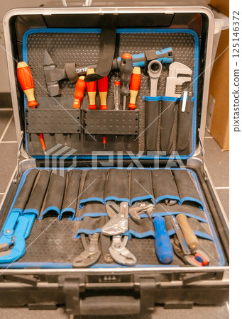 Open tool kit displaying assorted hand tools organized neatly. Includes screwdrivers, wrenches, and pliers. Ideal for repair tasks or mechanical work. Open tool kit displaying assorted hand tools organized neatly. Includes screwdrivers, wrenches, and pliers. Ideal for repair tasks or mechanical work. 125146372