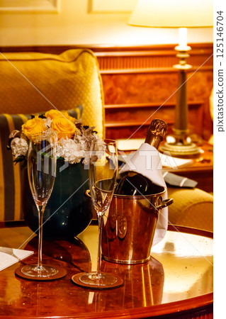Champagne bottle in an ice bucket with two champagne glasses Champagne bottle in an ice bucket with two champagne glasses 125146704