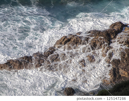 Ocean waves crushing against rocks Ocean waves crushing against rocks 125147286