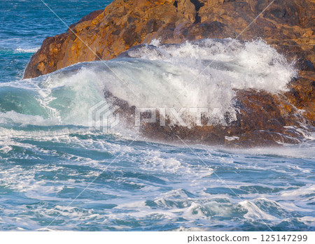 Ocean waves crushing against rocks Ocean waves crushing against rocks 125147299