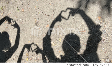 Shadow of three people making a heart with their hands_Wide Shadow of three people making a heart with their hands_Wide 125147384