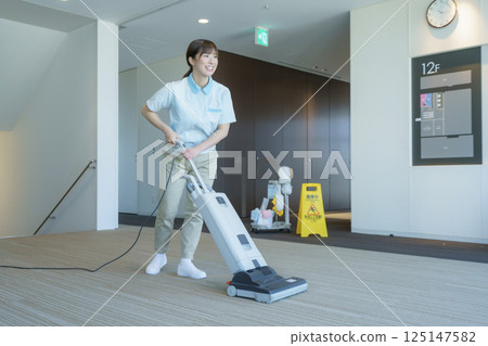 A young female cleaner vacuums the floor of an office building. Photo courtesy of Tokyo Electronics College, Denpa Gakuen Corporation A young female cleaner vacuums the floor of an office building. Photo courtesy of Tokyo Electronics College, Denpa Gakuen Corporation 125147582