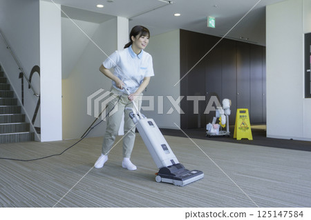 A young female cleaner vacuums the floor of an office building. Photo courtesy of Tokyo Electronics College, Denpa Gakuen Corporation A young female cleaner vacuums the floor of an office building. Photo courtesy of Tokyo Electronics College, Denpa Gakuen Corporation 125147584