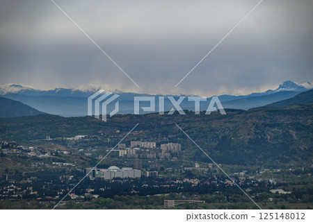 Cityscape view of Tbilisi, the capital of Georgia with snow-capped Caucasus mountains in the distance 125148012