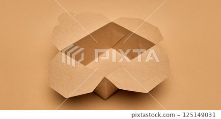 Open cardboard food box with flaps unfolded against light brown background. Sustainable takeaway solutions. Eco-friendly packaging, food delivery, Open cardboard food box with flaps unfolded against light brown background. Sustainable takeaway solutions. Eco-friendly packaging, food delivery, 125149031