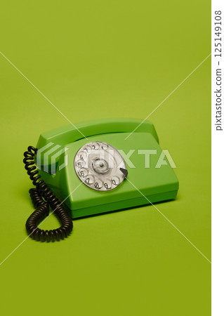 Vintage green rotary phone on bright green background. Concept of retro communication, nostalgia, vintage style. 125149108