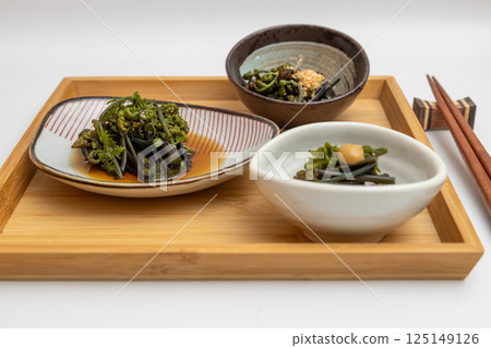 用野菜做成的三道菜擺放在托盤上：煮青菜、芝麻醬等春季菜餚 125149126