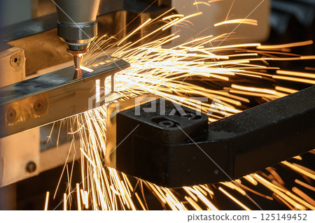 Close up scene the fiber laser cutting machine cut the square shape stainless steel tube with sparkling light. 125149452