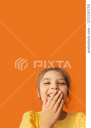Vertical portrait of funny smiley happy girl six years old in yellow T-shirt on orange background, copy space 125150158