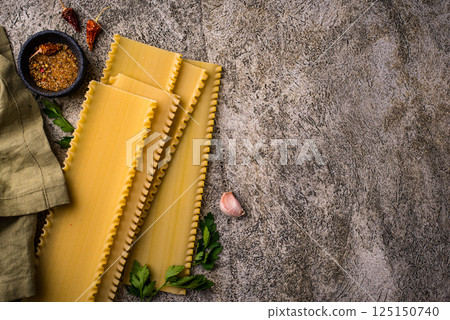 Uncooked lasagna pasta with cooking ingredient 125150740