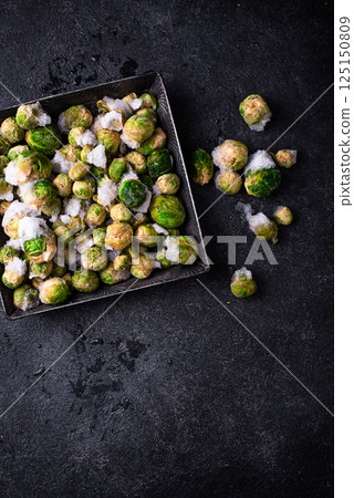 Frozen Brussels sprouts on dark background Frozen Brussels sprouts on dark background 125150809
