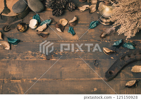 Witchcraft atmospheric flat lay. Dry herbs, blue flower petals, stones, small lantern, old horseshoe, birds feather on rude wooden surface, copy space. Witchcraft atmospheric flat lay. Dry herbs, blue flower petals, stones, small lantern, old horseshoe, birds feather on rude wooden surface, copy space. 125150928