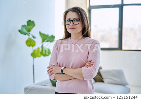 Confident successful mature beautiful woman looking at camera with crossed arms 125151244