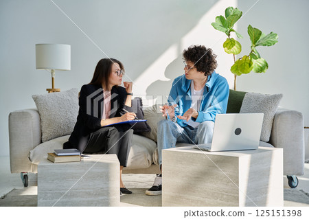 Mental therapy session, young guy talking with female psychologist, in office Mental therapy session, young guy talking with female psychologist, in office 125151398