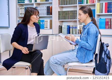 Female teacher, counselor working with college student teenage girl Female teacher, counselor working with college student teenage girl 125151415