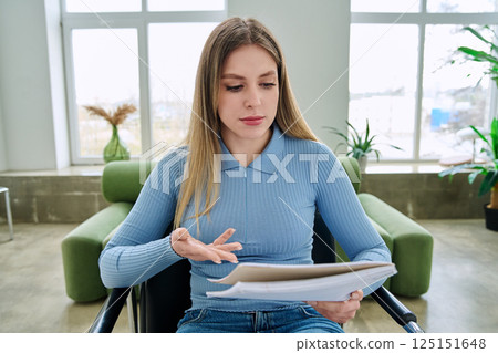 Webcam view young female student with textbook in hands, sitting at home Webcam view young female student with textbook in hands, sitting at home 125151648