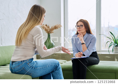Professional female therapist counselor psychologist working with young woman patient Professional female therapist counselor psychologist working with young woman patient 125151668