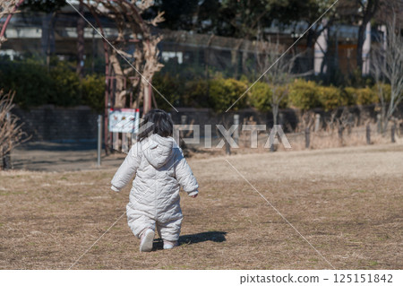 [A one-year-old child playing on the grass at Sagamihara City Asamizo Park, from behind] 125151842