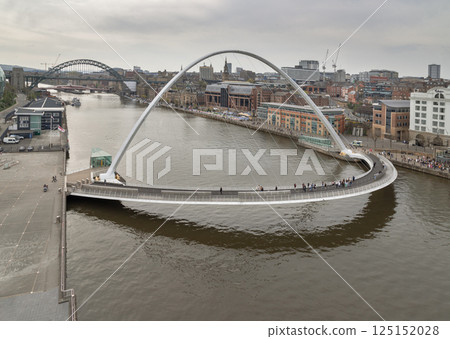 Beautiful view of The Iconic gateshead millennium bridge spanning the River Tyne with Ancient buildings and Tyne bridge in the background. Beautiful view of The Iconic gateshead millennium bridge spanning the River Tyne with Ancient buildings and Tyne bridge in the background. 125152028
